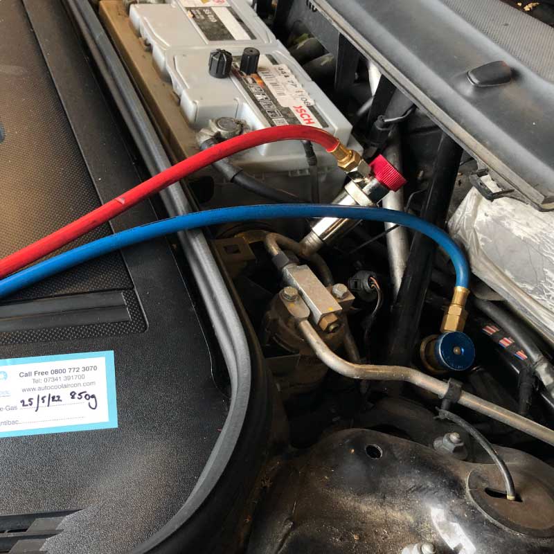 Air con regas hoses connected under the bonnet during a service